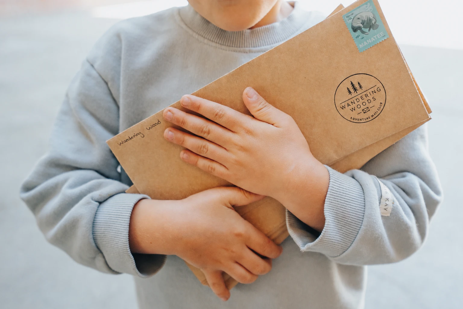 A child holding a Wandering Woods travel letter